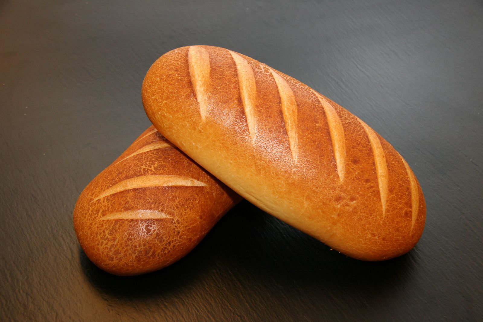 Two embergrain loaves resting on black slate