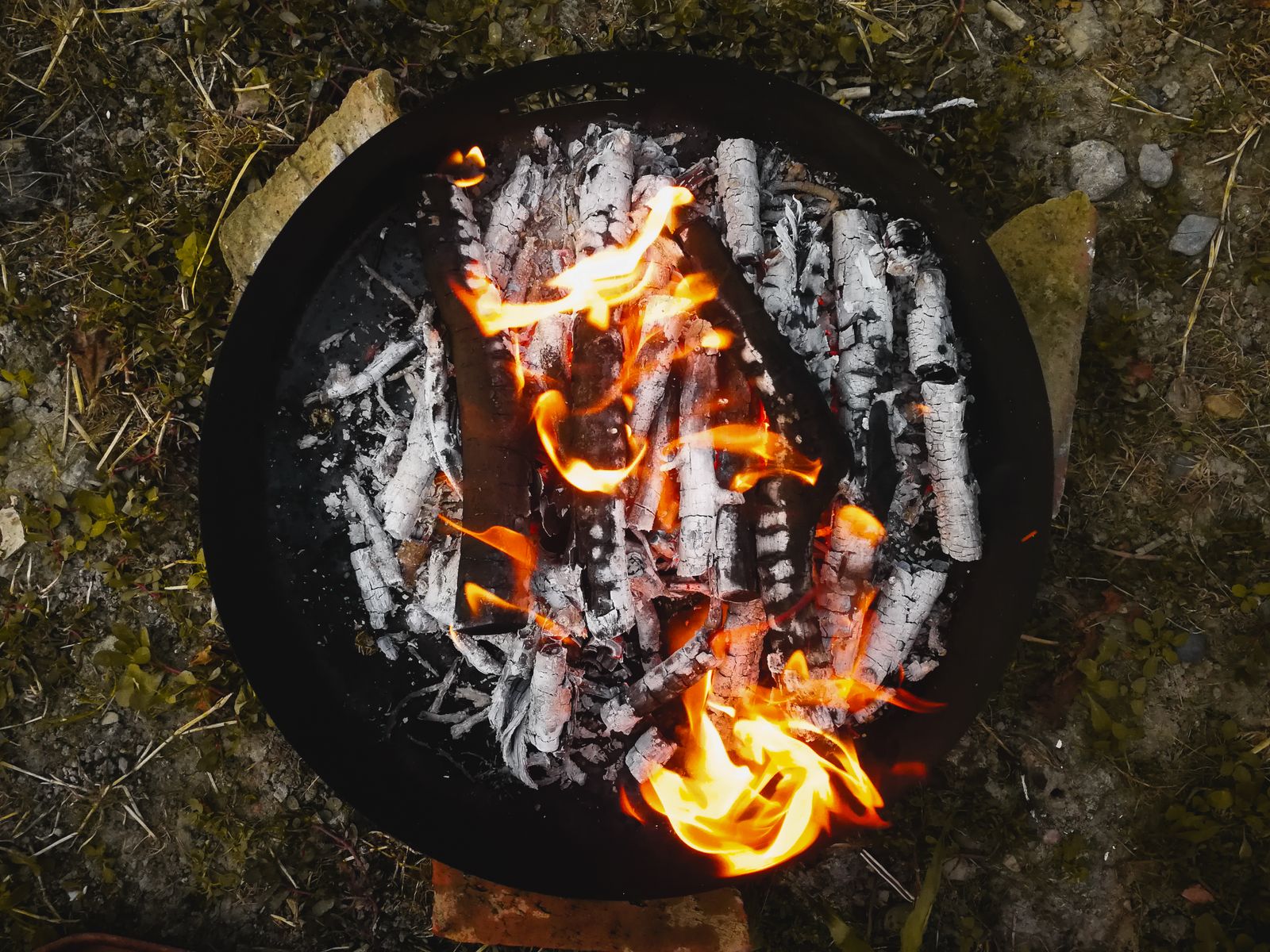Overhead view of the fire bowl, logs burned to white ash and flame