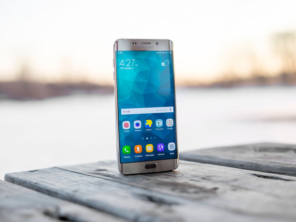 Edge-display smartphone standing on wood