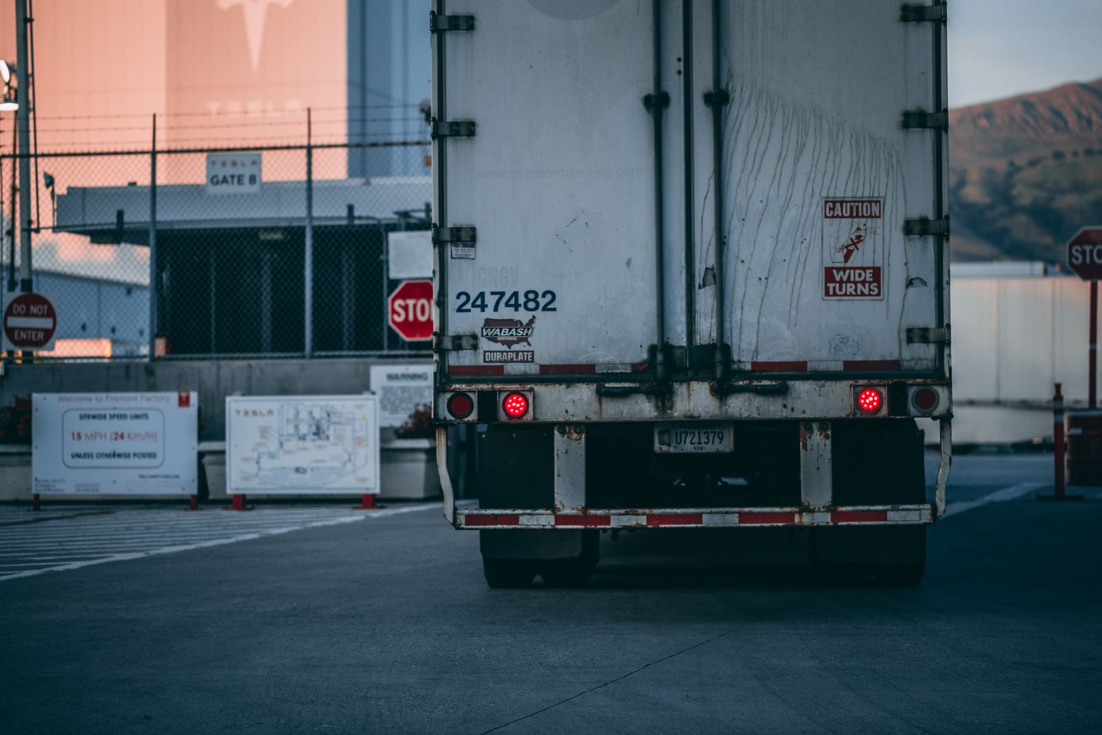 Semi trailer at industrial gate, no people visible